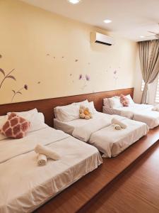 three beds in a room with stuffed animals on them at Suriaman Serenity Comfort Home 4R4B 芙蓉宁静舒适之家 4房4卫 in Kampong Gadong Jaya