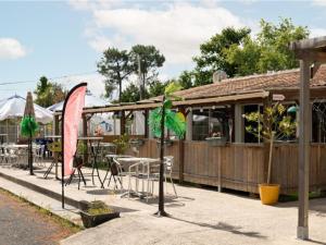 Mobil-home 32m² pour 8 pers, terrasse, Saint-Sornin - API-1-52-399 في Saint-Sornin: مطعم به طاولات وكراسي أمام مبنى +15 صورة