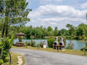 Chalet avec Terrasse à Saint-Sornin pour 4 personnes - API-1-52-414 في Saint-Sornin: حديقة بها بحيرة وطاولة وكراسي