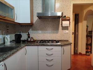 a kitchen with white cabinets and a stove top oven at Classic 3BR Sintra Home near Beaches & Palaces in Colares