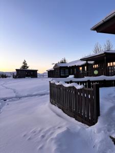 a house in the snow with a fence at Hotel Brú countryside in Selfoss