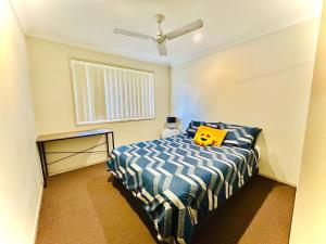 Dormitorio con cama con almohada amarilla en JP Homestay Private Rooms in Homely Shared Home in North Booval, Ipswich City, en Bundamba
