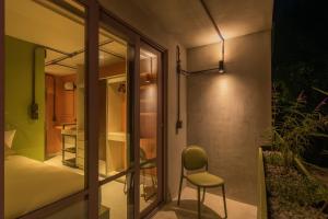 贾拉普Nico Hotel & Residences的一间带椅子的房间和一间带卧室的房间