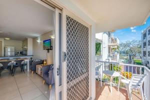 a balcony with a view of a dining room and kitchen at Shoreline Apartments - Unit 4a in Bargara