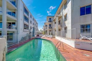 a swimming pool in the courtyard of a apartment building at Shoreline Apartments - Unit 4a in Bargara +5 photos