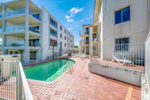 an apartment building with a swimming pool next to a building at Shoreline Apartments - Unit 4a in Bargara