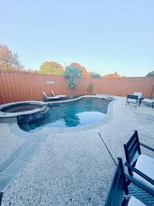 een klein zwembad met 2 stoelen en een hek bij Spacious Centrally Located with Heated Pool in Frisco
