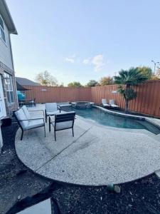 een terras met een tafel en stoelen naast een zwembad bij Spacious Centrally Located with Heated Pool in Frisco +34 foto's