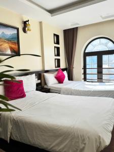 two beds in a hotel room with red pillows at Sapphire Sapa Hotel in Sapa +37 photos