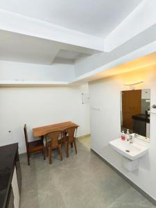 a bathroom with a table and a sink in a room at Urban villa in Trivandrum +1 photo