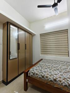 a bedroom with a bed and a ceiling fan at Urban villa in Trivandrum