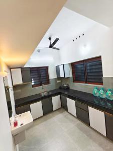 a kitchen with black and white counters and a ceiling at Urban villa in Trivandrum