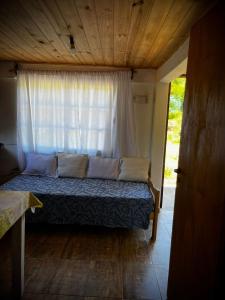 una cama en una habitación con ventana en Luli 1, en Villa Gesell 31 fotos más