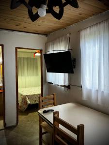 Una sala de estar con una mesa y un televisor. en Luli 1, en Villa Gesell