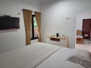 a bedroom with a bed and a flat screen tv at Grand Ciwareng Inn Hotel and Resort in Pasarsenen +98 photos