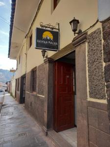 Un edificio con una puerta roja y un cartel en ella. en hawka pacha cusqueña, en Cusco