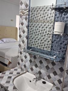 a bathroom with a sink and a mirror and a bed at Grand Ciwareng Inn Hotel and Resort in Pasarsenen