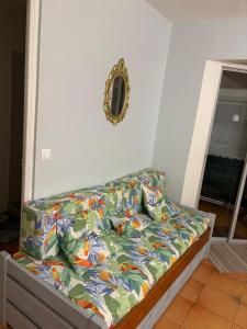 a bed with a comforter on it in a bedroom at Le Ara Bleu in Les Trois-Îlets