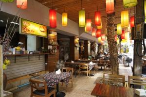 een restaurant met tafels en stoelen en Chinese verlichting bij Taradii Boutique -Villa Cha-Cha Khoasan Rambuttri in Bangkok