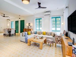 Valencia By DanCenter - 3 Bhk Villa in Siolim في Camorlim: غرفة معيشة بها أريكة وطاولة