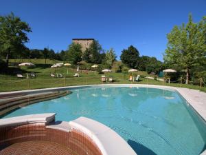 a large swimming pool with chairs and umbrellas at Mansion in Apecchio with Pool in Apecchio