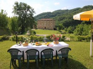 a table with a white tablecloth and chairs and a building at Mansion in Apecchio with Pool in Apecchio