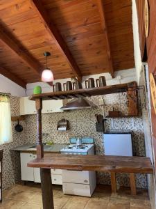 Una cocina con techo de madera y un banco de madera. en Cabañas Canaan, en La Cumbre