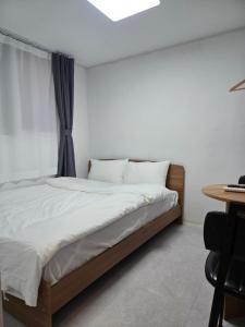 a bedroom with a bed and a desk and a window at 목포 달달마실 게스트하우스 in Mokpo