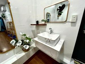 a white bathroom with a sink and a mirror at Dốc Biển Homestay Mui Ne in Ấp Khánh Phước (1) +31 photos