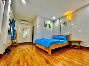 a bedroom with a blue bed and a wooden floor at Dốc Biển Homestay Mui Ne in Ấp Khánh Phước (1)
