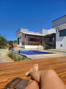 a man laying on a deck in front of a house at K&S Kanto Sereno in Pirenópolis