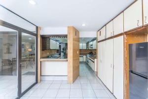 a kitchen with white cabinets and a large window at Family Home with Private Pool in Guadalajara