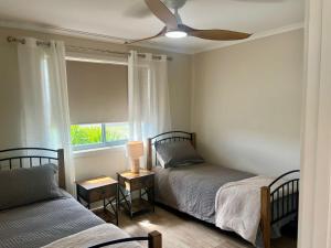 a bedroom with two beds and a ceiling fan at Solmar Siesta - WiFi Pet Friendly Outside in Robe