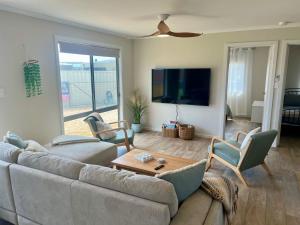 a living room with a couch and a flat screen tv at Solmar Siesta - WiFi Pet Friendly Outside in Robe +17 photos