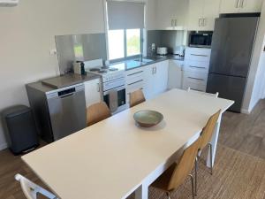 a kitchen with a white table with chairs and appliances at Solmar Siesta - WiFi Pet Friendly Outside in Robe