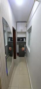 ein Flur zu einem Zimmer mit Küche und Treppe in der Unterkunft O'sena in Cotonou + 26 Fotos