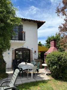 a patio with a table and chairs in front of a house at Chalet Caserón de Tejas, Amplia y confortable casa para hasta 11 huéspedes in Mar del Plata