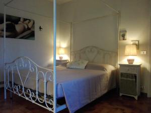 a bedroom with a white bed with a canopy at Casa Badinot in Diano dʼAlba