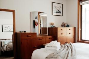 Un dormitorio con una cama, una cómoda y un espejo. en StudioNESS, en Scamander