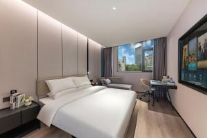 Un dormitorio con una cama blanca grande y un escritorio en Urna Hotel Xiamen Railway Station Lianhua Road Subway Station Branch, en Xiamen 90 fotos más