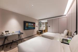 una habitación de hotel con una cama y un escritorio en Urna Hotel Xiamen Railway Station Lianhua Road Subway Station Branch, en Xiamen