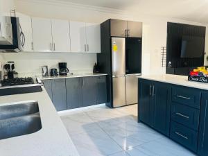 a kitchen with blue cabinets and a stainless steel refrigerator at Redhills Escape in Kingston