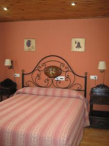 ein Schlafzimmer mit einem Bett mit einer rosa Wand in der Unterkunft Casa La Abadía in Aramón Cerler