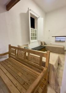 a bedroom with a wooden bed and a window at Casarão Centenário in Passos