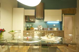 eine große Küche mit einem Glastisch darin in der Unterkunft Fico Blu in Rom