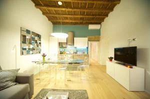 ein Wohnzimmer mit einem Glastisch und eine Küche in der Unterkunft Fico Blu in Rom