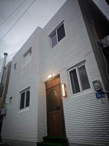 a house with a wooden door on the side of it at 목포 달달마실 게스트하우스 in Mokpo