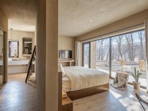 中卫大乐之野（中卫黄河宿集店）的一间卧室，里面有一张床和一扇大窗户。 更多105张照片