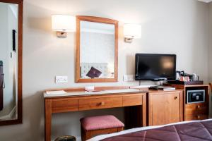 a bedroom with a large mirror and a television at The Red Lion Hotel in Hillingdon