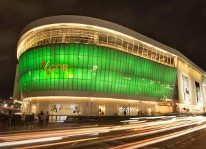 a large building with a green facade at night at Comfortable and quiet double room in Santo Domingo